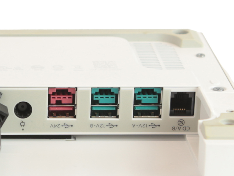 Zbliżenie na tylny panel bazy I/O HP Engage One z portami USB, LAN oraz złączem zasilania 24V.