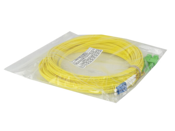 Zwinięty żółty kabel światłowodowy w foliowej torebce, widoczne złącza LC i SC na końcach oraz naklejka z opisem.