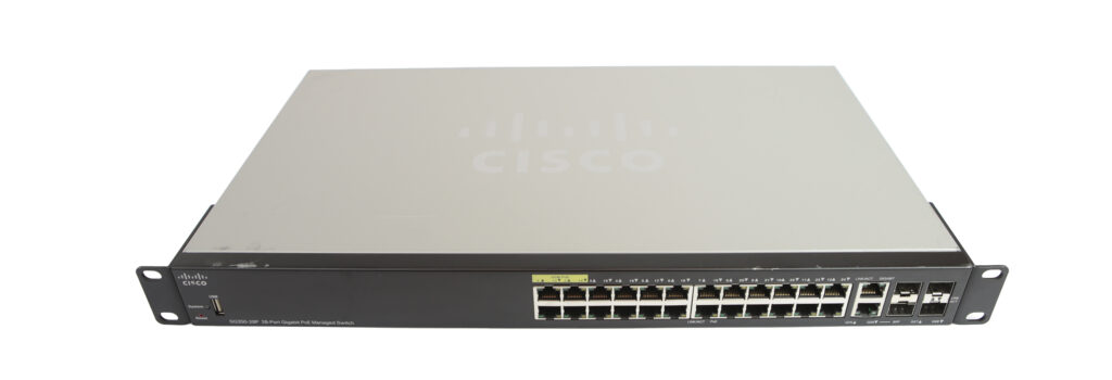 Przedni panel switcha Cisco z rzędem 24 portów RJ45 i uszami montażowymi po bokach obudowy.