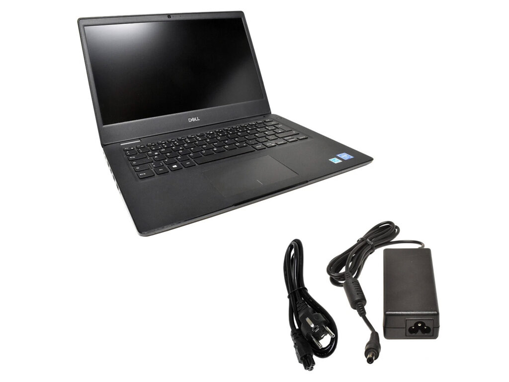 Otwarty laptop Dell z widoczną klawiaturą i zaślepionym ekranem, poniżej zasilacz z kablem zasilającym.