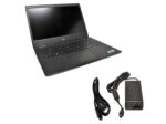 Otwarty laptop Dell z klawiaturą i ekranem oraz obok zasilacz z kablem zasilającym.