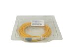 Zwinięty żółty kabel światłowodowy patchcord ze złączami LC i FC, zapakowany w plastikowe pudełko blistrowe.