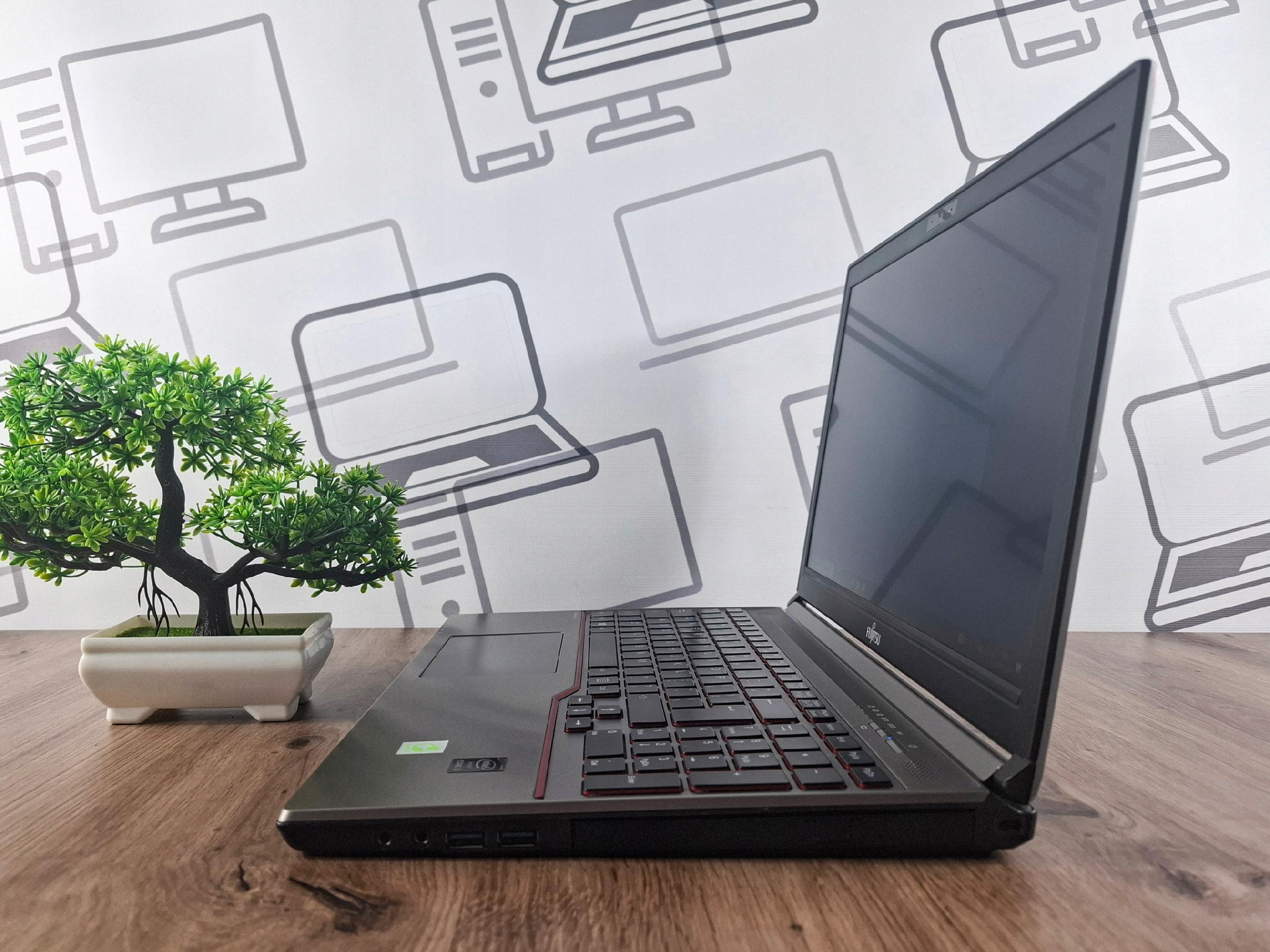 Laptop Fujitsu Lifebook otwarty pod kątem z boku, widoczna klawiatura i ekran, ekran wyłączony.