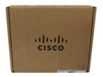 Zamknięte kartonowe pudełko z logo Cisco i naklejką z etykietą na dolnej krawędzi, widok pod kątem.