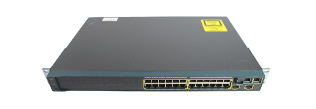 Przedni panel switcha Cisco z 24 portami RJ45, dwoma slotami SFP i rzędami diod stanu, obudowa z uszami montażowymi.