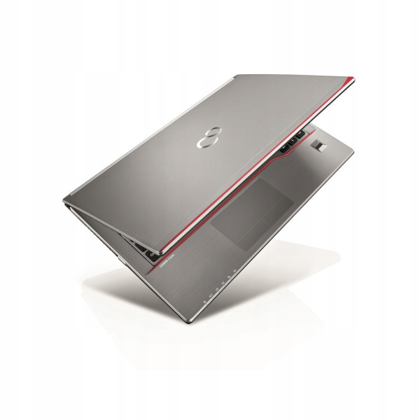 Laptop Fujitsu uchylony pod kątem, widok od tyłu na pokrywę matrycy w kolorze srebrnym z czerwoną obwódką.