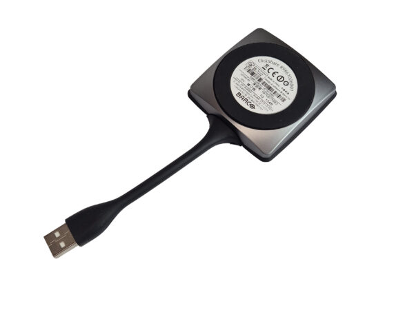 Przycisk Barco ClickShare z krótkim giętkim przewodem zakończonym wtyczką USB-A, widok od tyłu z naklejką z certyfikatami.