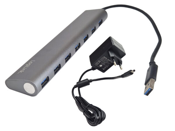 Aluminiowy hub USB LogiLink z siedmioma portami USB 3.0 w rzędzie, obok kabel USB-A i dołączony zasilacz sieciowy.
