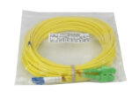 Zwinięty żółty kabel światłowodowy patchcord w foliowej torebce, ze złączami LC i SC na końcach.