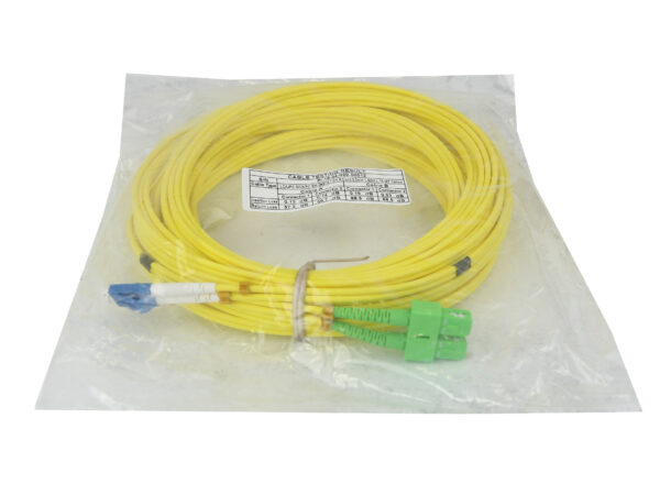Żółty kabel światłowodowy zwinięty w kółko, zapakowany w przezroczystą torebkę foliową, ze złączami LC i zielonym SC widocznymi na końcach.