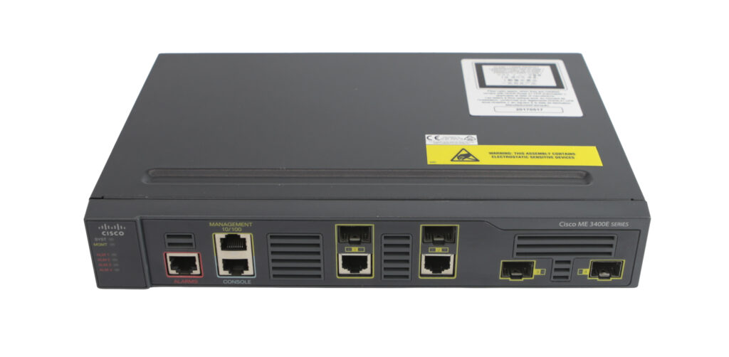Przedni panel switcha Cisco z portami RJ45 i SFP oraz naklejkami z oznaczeniami na górnej pokrywie obudowy.
