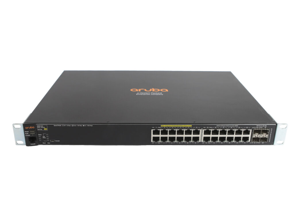 Przedni panel switcha Aruba z 24 portami RJ45 i czterema slotami SFP, widoczne uszy montażowe do szafy rack.