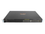 Przedni panel switcha Aruba z 24 portami RJ45 i czterema slotami SFP, widoczne uszy montażowe do szafy rack.
