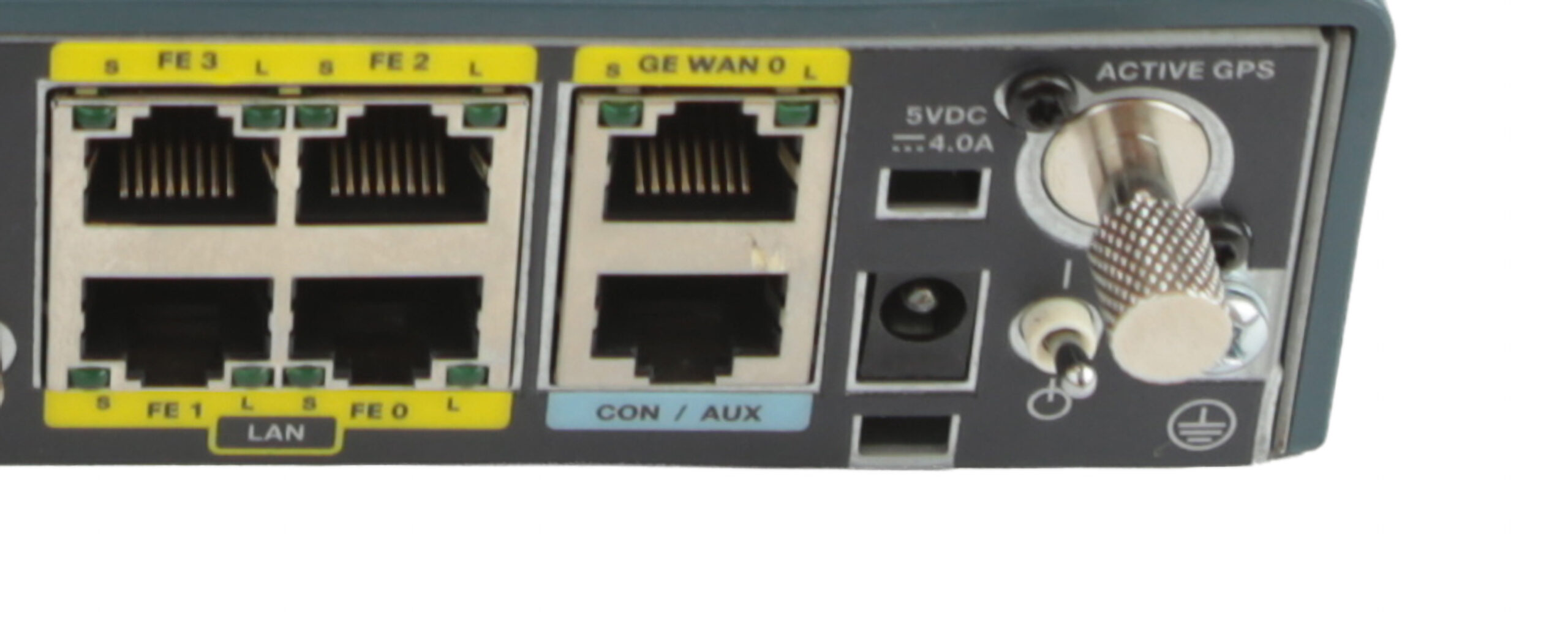 Zbliżenie na panel routera Cisco z czterema portami FE RJ45, portem GE WAN, gniazdem zasilania i złączem anteny GPS.