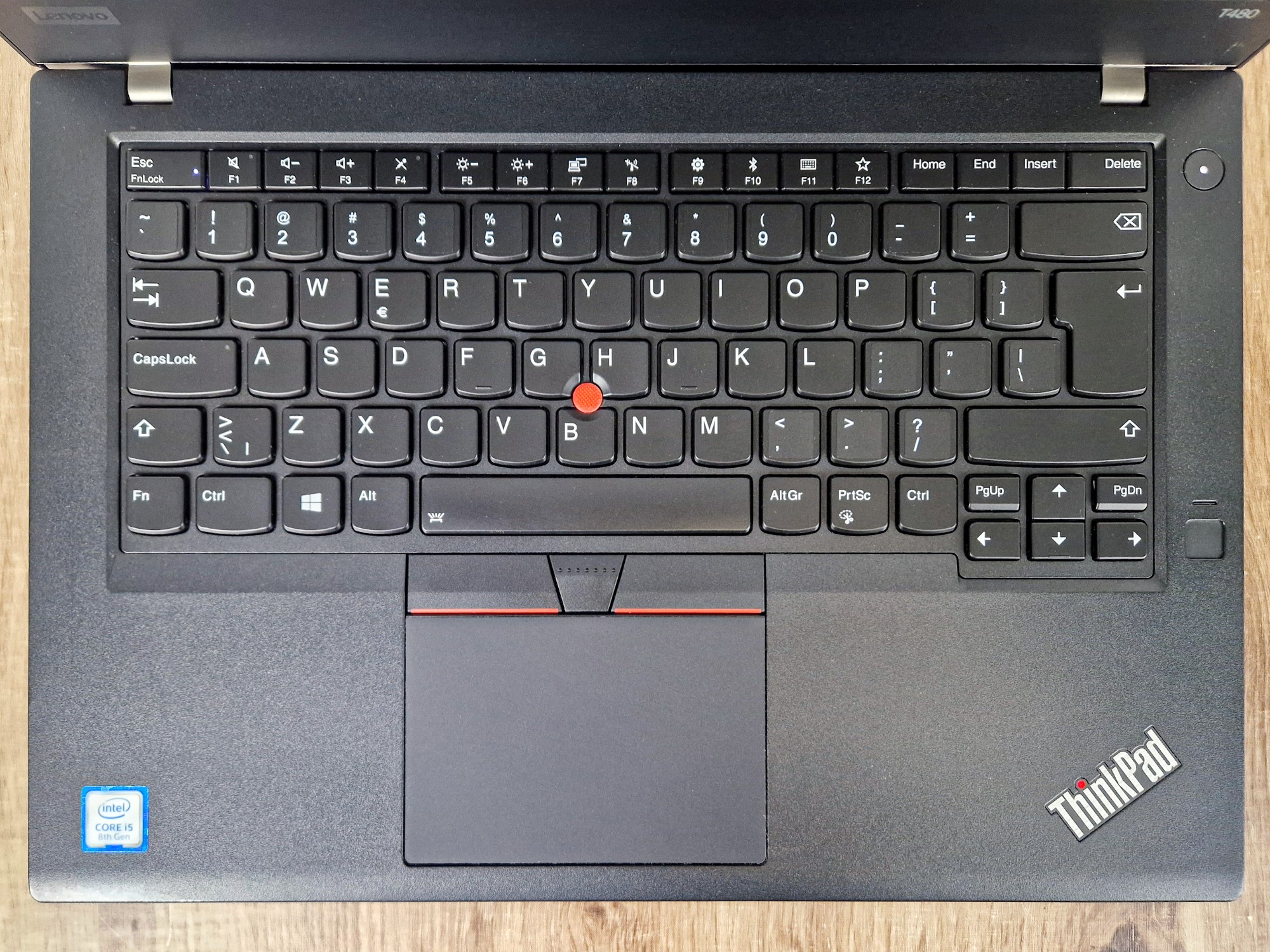 Widok z góry na otwartego ThinkPada T480 - klawiatura, touchpad i czerwony trackpoint, obudowa bez widocznych przetarć.
