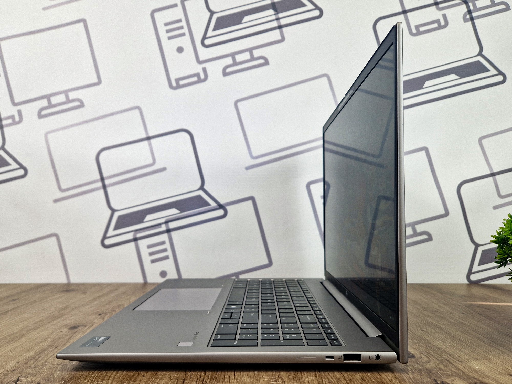Laptop HP ZBook Firefly uchwycony z boku pod kątem, otwarty, widoczna klawiatura i profil cienkiej obudowy z portem USB-C.