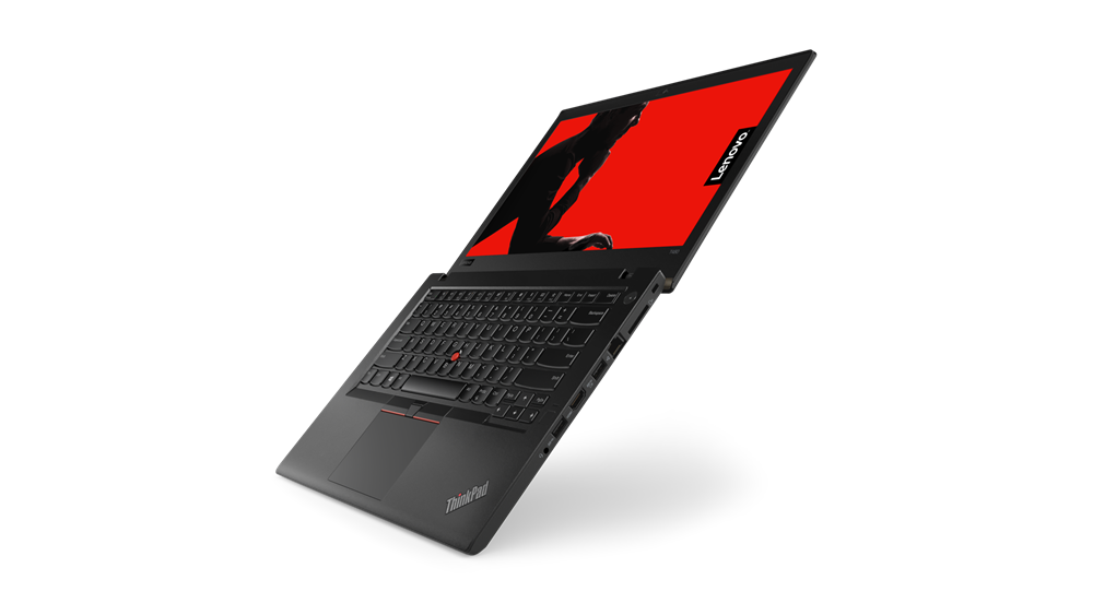 Laptop Lenovo ThinkPad uchwycony w locie pod kątem, ekran z czerwoną grafiką i logo ThinkPad, widoczna klawiatura.