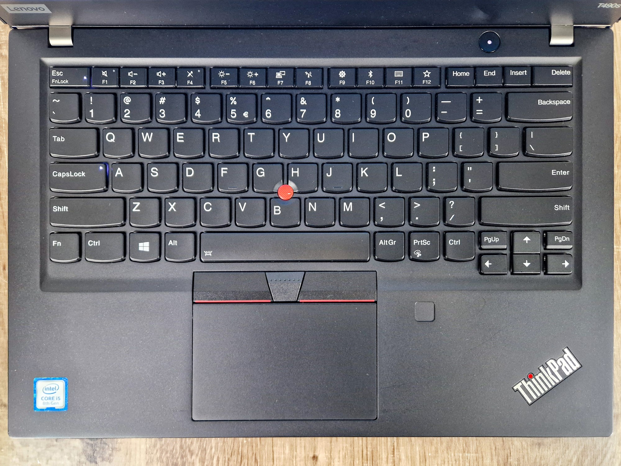 Laptop ThinkPad T490s z góry, widok na klawiaturę z czerwonym trackpointem i touchpad z czytnikiem linii papilarnych.