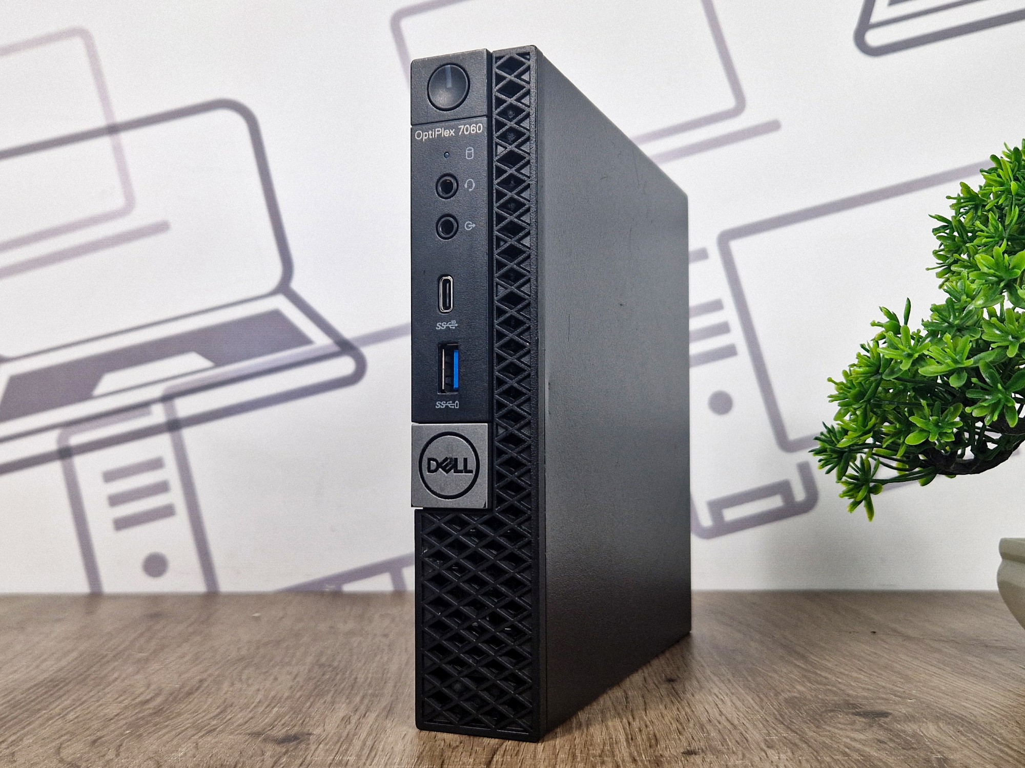 Komputer Dell OptiPlex 7060 Tiny pod kątem z boku, widoczny przycisk zasilania i porty USB na przodzie obudowy.