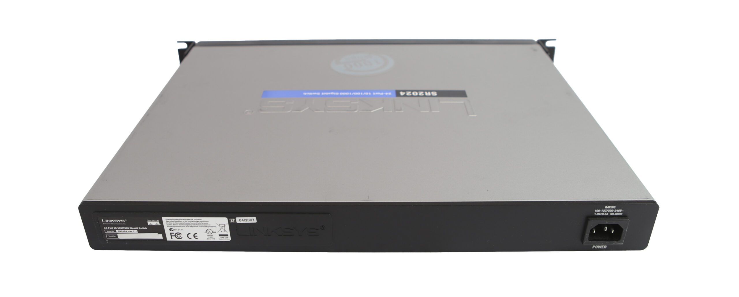 Widok z boku na obudowę switcha Cisco Linksys z uchem montażowym do szafy rack i gniazdem zasilania z tyłu.