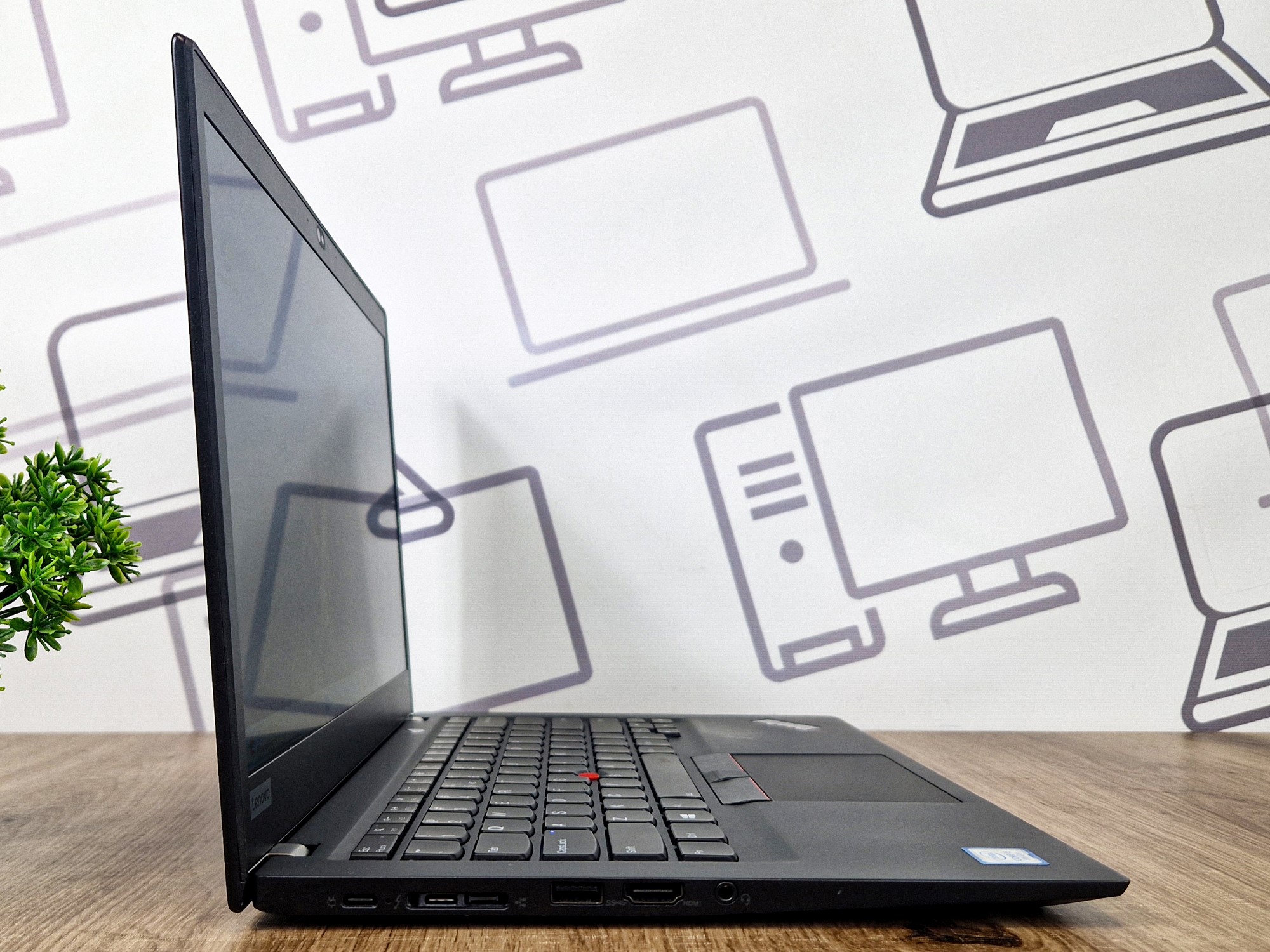 Laptop Lenovo ThinkPad otwarty pod kątem z boku, widok na profil ekranu i klawiaturę, ekran wygaszony.