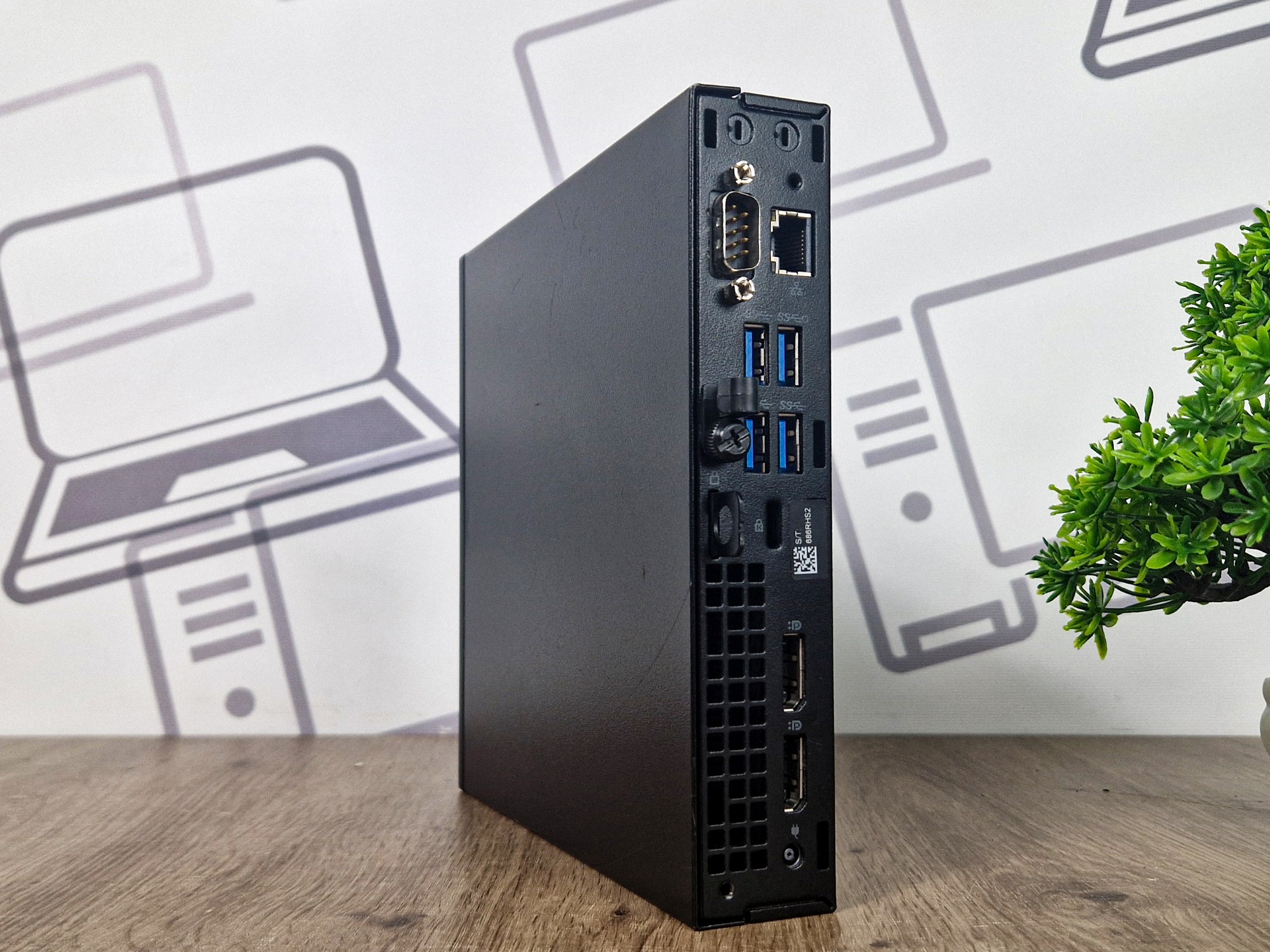 Komputer Dell OptiPlex 7060 Tiny pod kątem z boku, widoczne porty USB, złącze sieciowe i wylot wentylacji na obudowie.