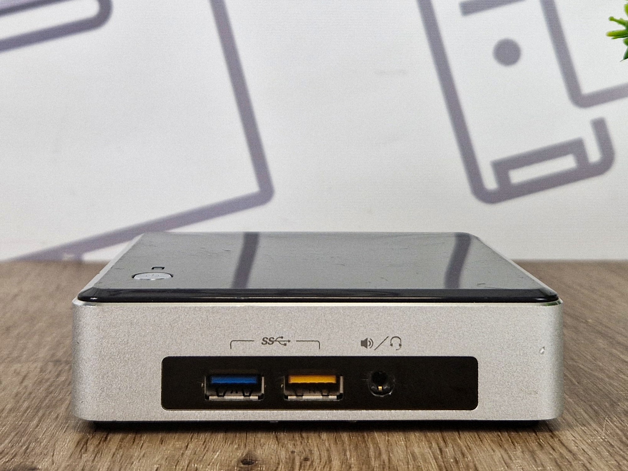 Przedni panel mini komputera Intel NUC z portem USB 3.0, USB 2.0 i gniazdem słuchawkowym, obudowa bez widocznych uszkodzeń.